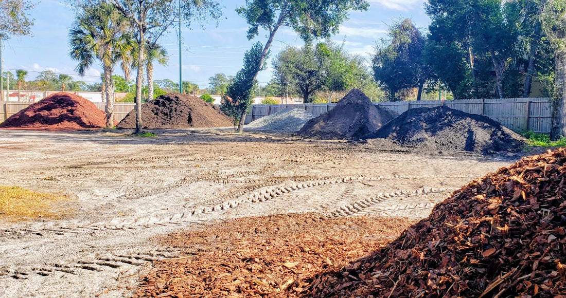 Bulk landscape materials yard showing multiple material piles measured by volume
