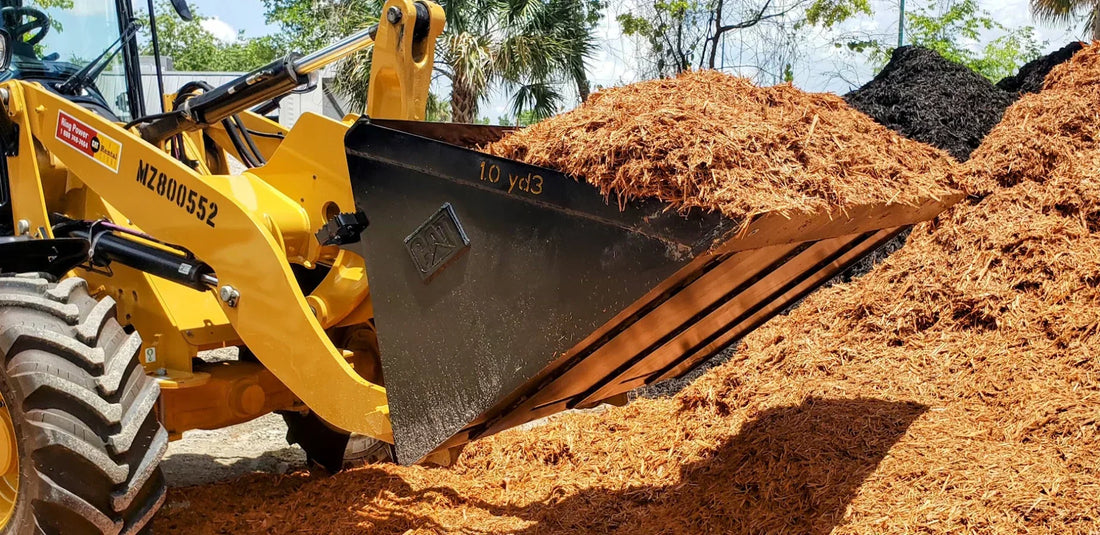 CAT loader with a full 1 cubic yard mulch bucket at a bulk landscape supply yard