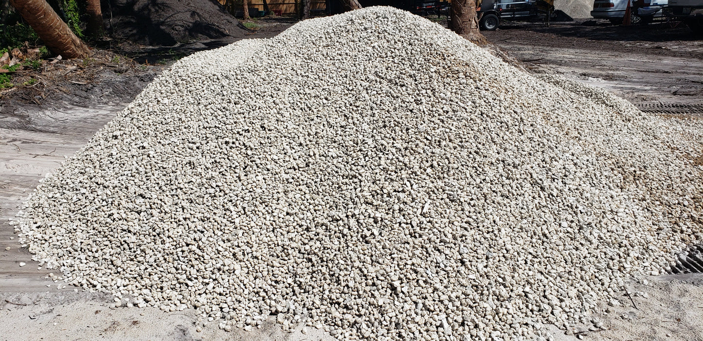 Bulk pile of #57 Limestone gravel for landscaping, driveways, and construction projects, clean and high-quality aggregate from Florida supplier.