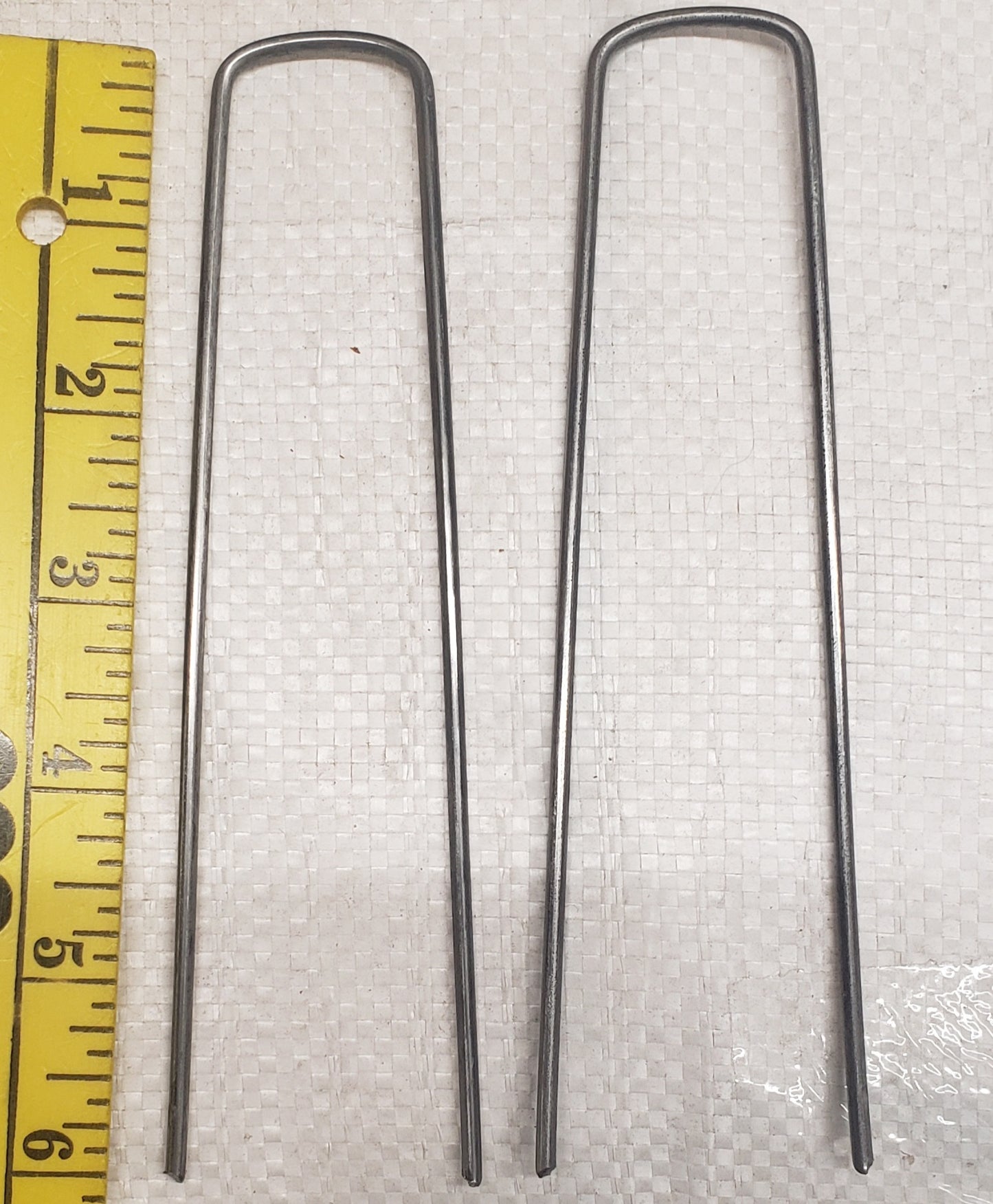 Close-up of a 6-inch galvanized landscape staple for securing weed barrier, landscape fabric, sod, and ground cover