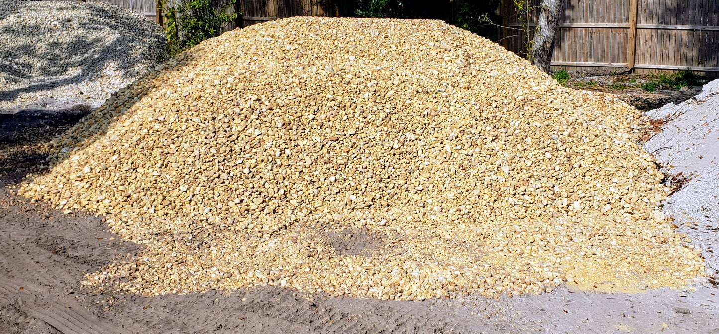 Bulk brown river rock pile showing 1 to 1.5 inch smooth round stones for landscaping, drainage, and decorative ground cover at Mulch and Stuff Ormond Beach