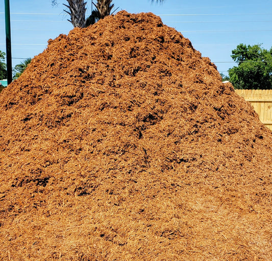 Large bulk pile of premium gold mulch for landscaping, gardens, and flower beds at Mulch and Stuff in Ormond Beach.
