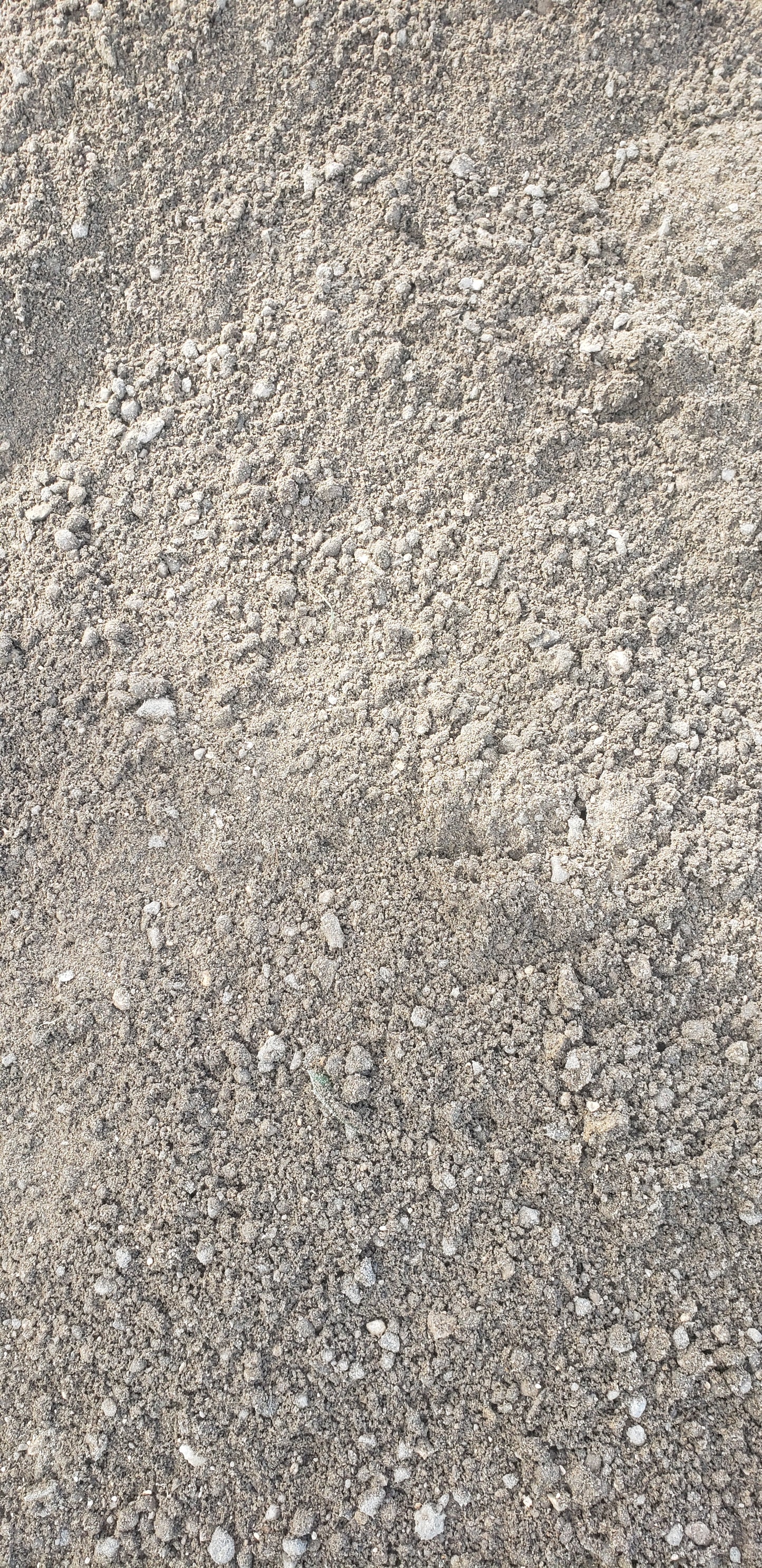 Close-up of Paver Base Type 2 Grade B showing crushed stone particles mixed with finely ground asphalt fines for superior compaction and drainage performance.