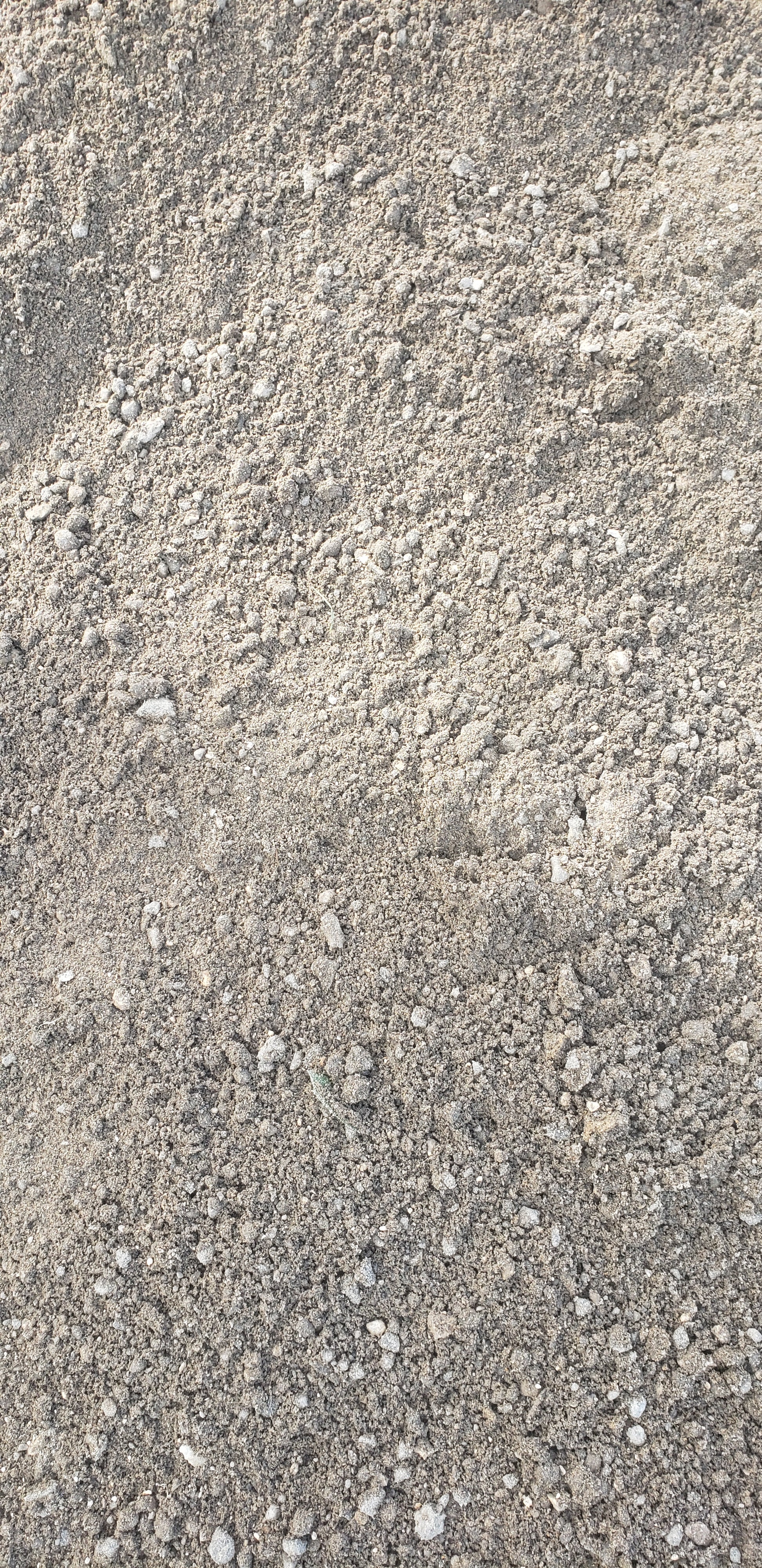 Close-up of Paver Base Type 2 Grade B showing crushed stone particles mixed with finely ground asphalt fines for superior compaction and drainage performance.